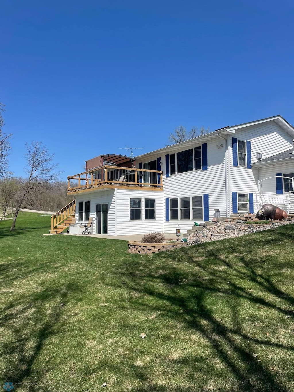 rear view of property featuring stairway and a yard