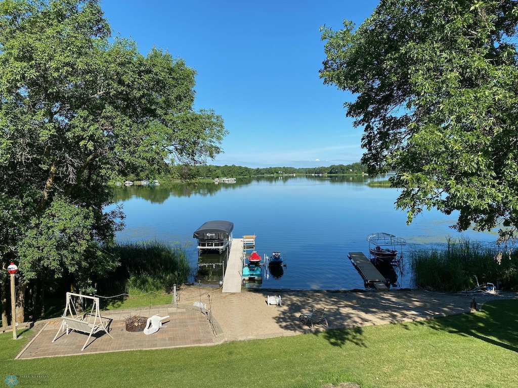 view of dock with a yard and a water view