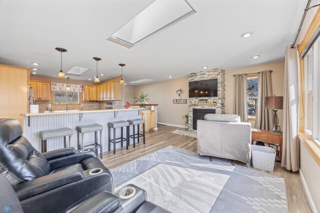 15344 Blackhawk Rd, Lake Eunice Twp, MN 56511 - living area featuring light wood-type flooring, baseboards, a fireplace, recessed lighting, and a skylight