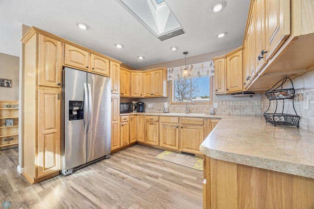 15344 Blackhawk Rd, Lake Eunice Twp, MN 56511 - kitchen featuring stainless steel fridge, a skylight, a sink, light wood-style floors, and light countertops