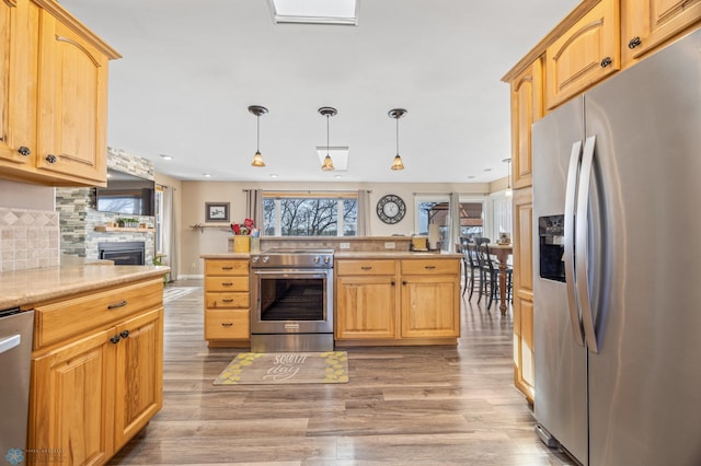15344 Blackhawk Rd, Lake Eunice Twp, MN 56511 - kitchen featuring appliances with stainless steel finishes, light wood-style flooring, light countertops, hanging light fixtures, and light brown cabinetry