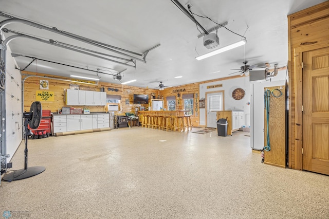 15344 Blackhawk Rd, Lake Eunice Twp, MN 56511 - garage with a ceiling fan, a garage door opener, and wooden walls