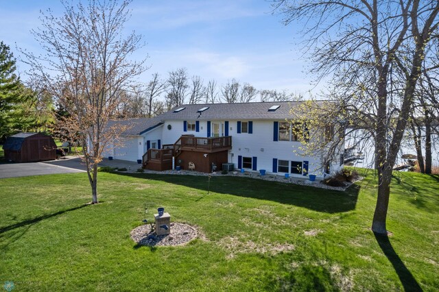 15344 Blackhawk Rd, Lake Eunice Twp, MN 56511 - view of front of house with a storage shed, a wooden deck, an outbuilding, asphalt driveway, and a front yard
