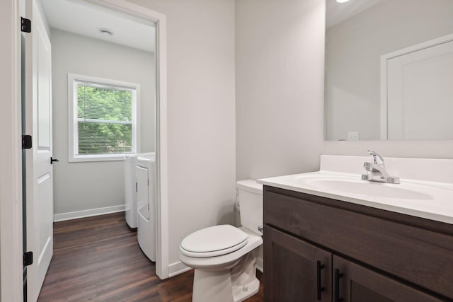 2219 Youngman Ave, Saint Paul, MN 55116 - bathroom with baseboards, toilet, vanity, wood finished floors, and washing machine and clothes dryer