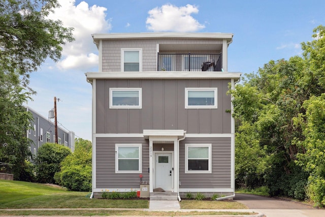 2219 Youngman Ave, Saint Paul, MN 55116 - view of front of home with board and batten siding, a front yard, and a balcony