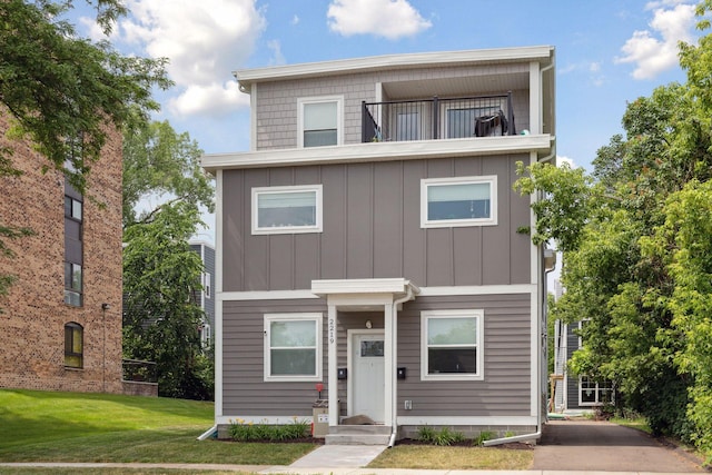 2219 Youngman Ave, Saint Paul, MN 55116 - view of front facade with a balcony, board and batten siding, and a front lawn