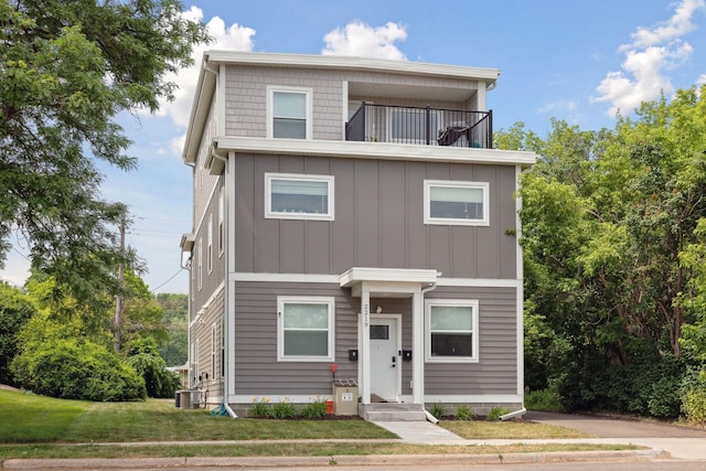 2219 Youngman Ave, Saint Paul, MN 55116 - contemporary house with board and batten siding, a front lawn, central AC, and a balcony