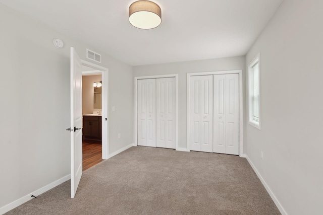 2219 Youngman Ave, Saint Paul, MN 55116 - unfurnished bedroom with carpet, visible vents, baseboards, and multiple closets