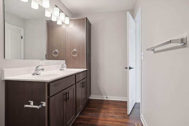 2219 Youngman Ave, Saint Paul, MN 55116 - bathroom featuring a sink, double vanity, baseboards, and wood finished floors