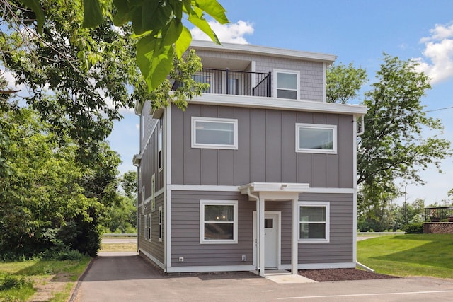 2219 Youngman Ave, Saint Paul, MN 55116 - view of front of house with board and batten siding, a front yard, and a balcony