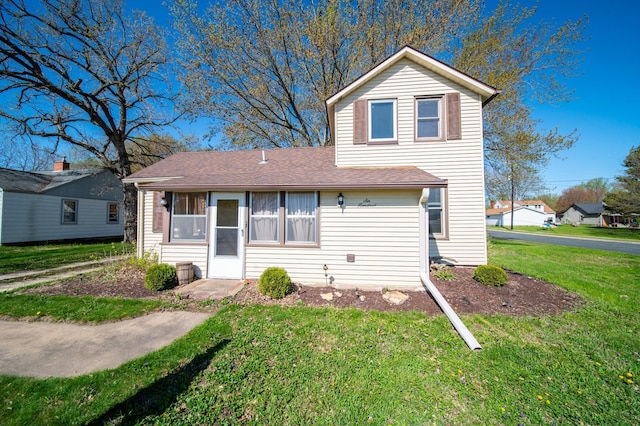 traditional-style home with a front yard and a shingled roof