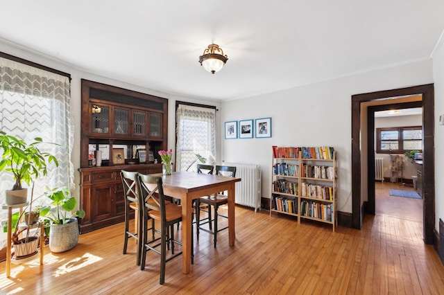 dining space with radiator, light wood finished floors, and a healthy amount of sunlight