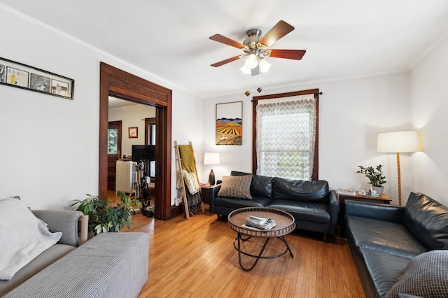 living room featuring ceiling fan, light wood-style flooring, a healthy amount of sunlight, and radiator heating unit