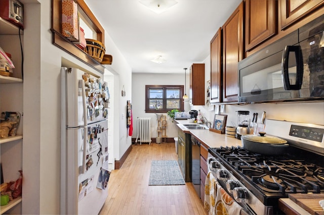 kitchen with brown cabinets, radiator, light wood-type flooring, black appliances, and light countertops