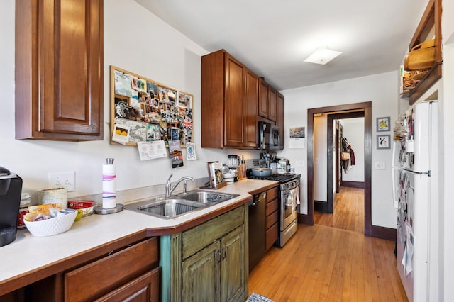 kitchen featuring a sink, stainless steel range with gas stovetop, black microwave, and light countertops