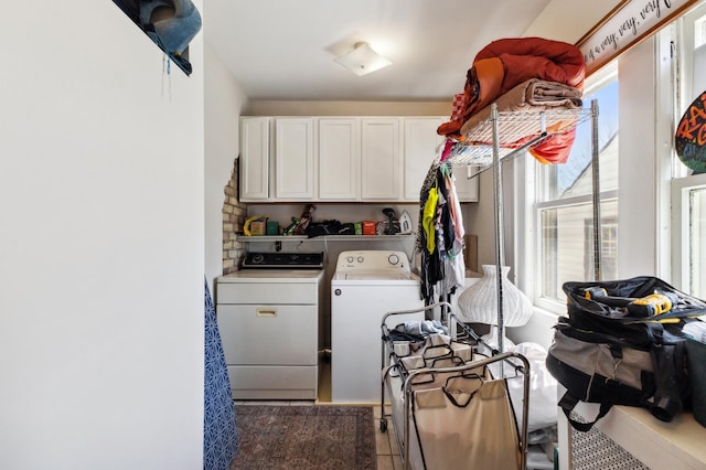 clothes washing area featuring washing machine and clothes dryer and cabinet space