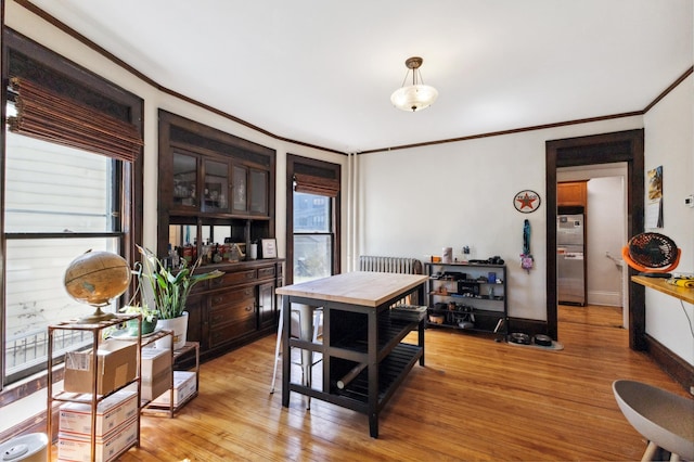 dining area featuring baseboards, ornamental molding, and light wood-style floors