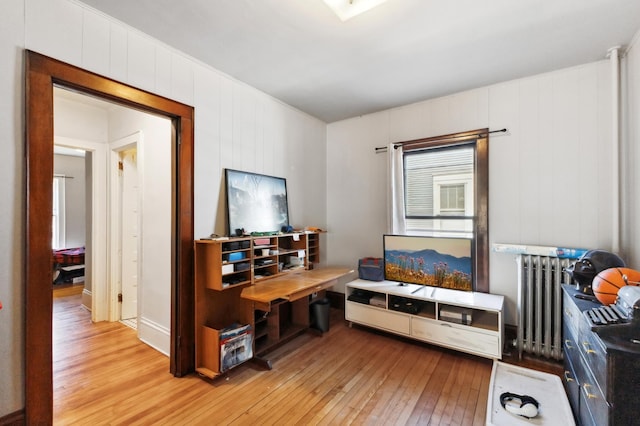 home office with light wood-style floors and radiator heating unit