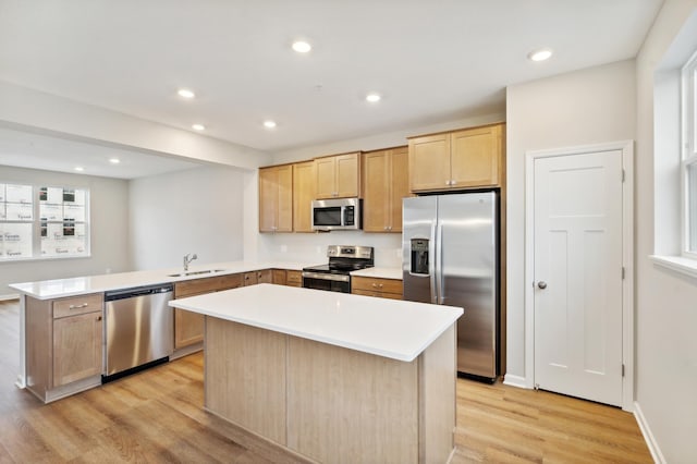 6742 Wildflower Way, Minnetrista, MN 55331 - kitchen featuring stainless steel appliances, a sink, a peninsula, light brown cabinetry, and light wood-style flooring