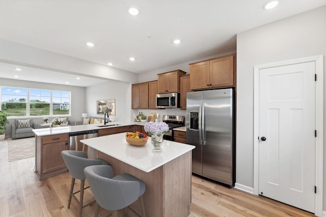 6742 Wildflower Way, Minnetrista, MN 55331 - kitchen featuring appliances with stainless steel finishes, a peninsula, light countertops, light wood-style floors, and open floor plan