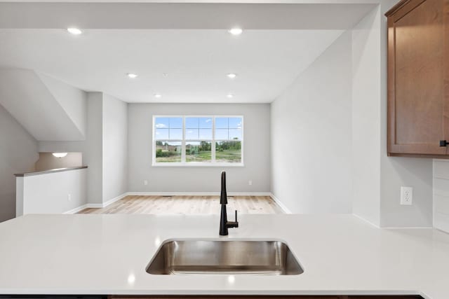 6742 Wildflower Way, Minnetrista, MN 55331 - kitchen with light wood-style flooring, light countertops, recessed lighting, brown cabinets, and open floor plan