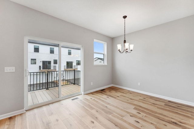 6742 Wildflower Way, Minnetrista, MN 55331 - spare room with light wood-style floors and a chandelier