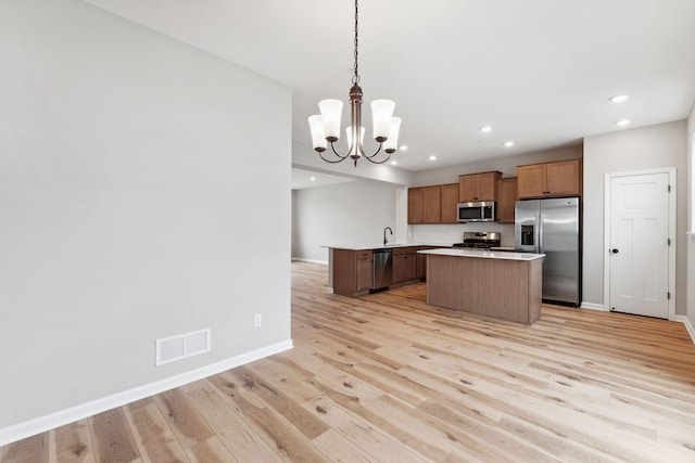 6742 Wildflower Way, Minnetrista, MN 55331 - kitchen with stainless steel appliances, a chandelier, a center island, light wood-style flooring, and recessed lighting