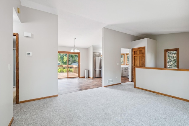 6913 Sumac Ct, Centerville, MN 55038 - spare room featuring carpet, a chandelier, and lofted ceiling