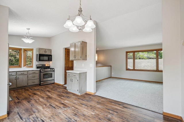 6913 Sumac Ct, Centerville, MN 55038 - kitchen with stainless steel range with gas cooktop, black microwave, light countertops, dark wood-style flooring, and a chandelier