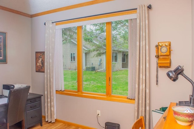 office area with light wood-type flooring, ornamental molding, and baseboards