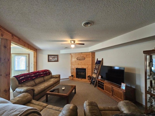 19319 Elsie Way NW, Bemidji, MN 56601 - living room with carpet flooring, a textured ceiling, visible vents, ceiling fan, and a large fireplace