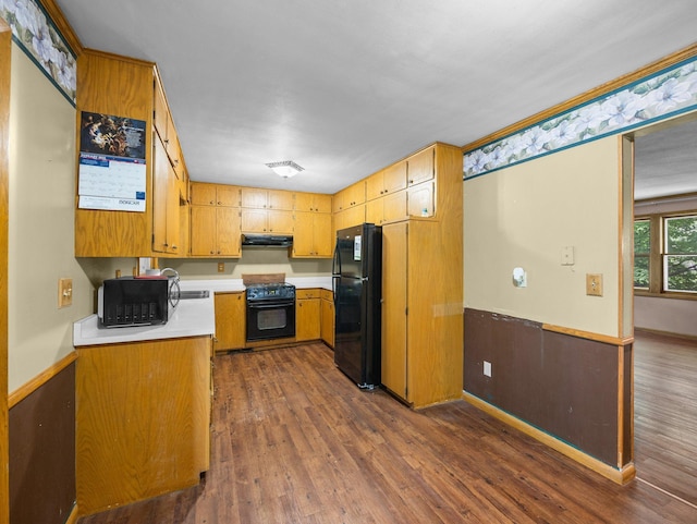 1716 9th Ave SE, Saint Cloud, MN 56304 - kitchen featuring black appliances, under cabinet range hood, light countertops, dark wood-style flooring, and brown cabinetry