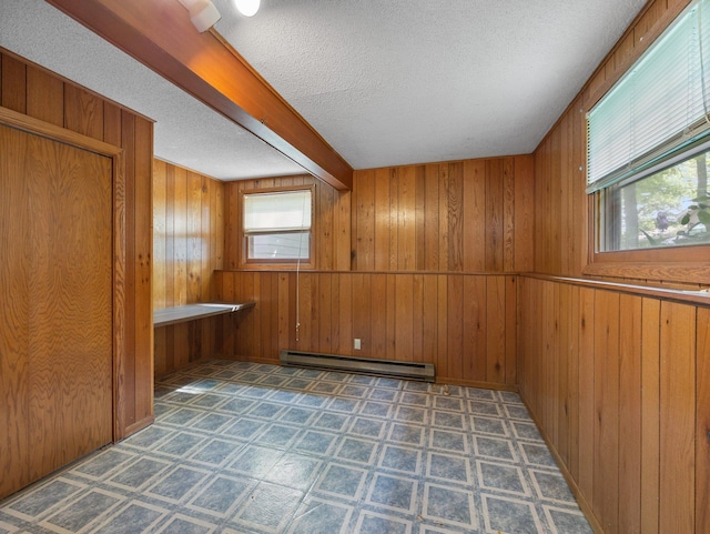 1716 9th Ave SE, Saint Cloud, MN 56304 - empty room with a baseboard radiator, a textured ceiling, wooden walls, and beamed ceiling