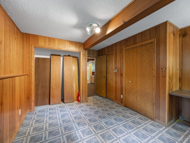 1716 9th Ave SE, Saint Cloud, MN 56304 - unfurnished bedroom featuring a textured ceiling, wood walls, and tile patterned floors