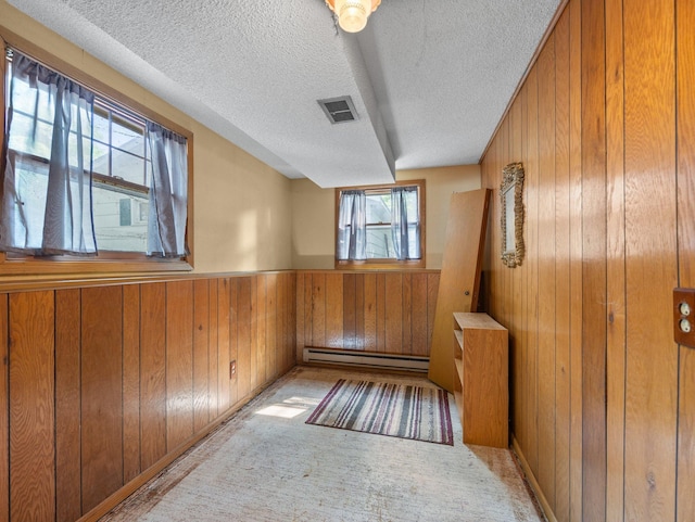1716 9th Ave SE, Saint Cloud, MN 56304 - unfurnished room with wooden walls, a baseboard radiator, a textured ceiling, and a wainscoted wall