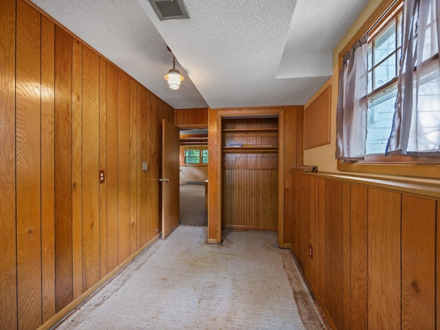 1716 9th Ave SE, Saint Cloud, MN 56304 - hallway featuring wood walls, a textured ceiling, and light carpet