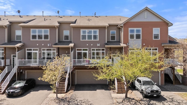 rear view of property with stairway and a garage
