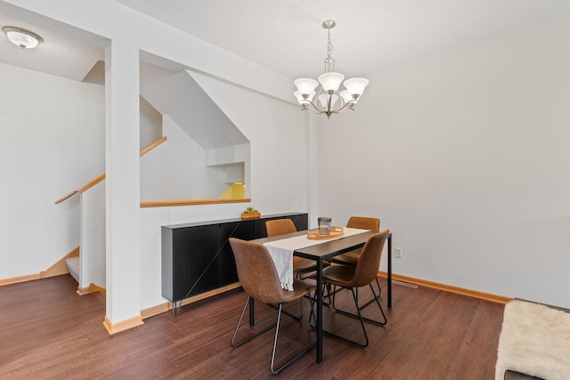 dining space featuring baseboards, an inviting chandelier, and wood finished floors