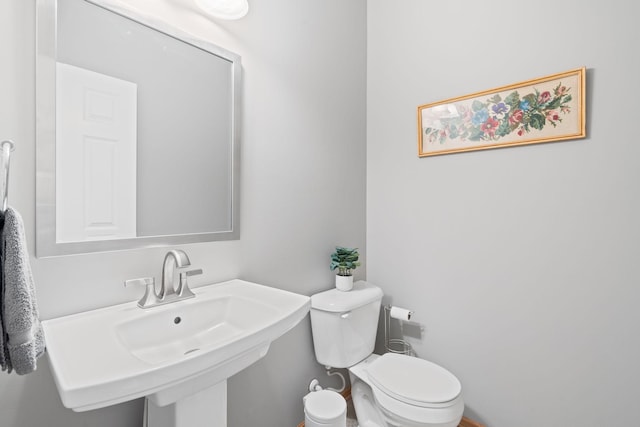 half bath featuring toilet and a sink