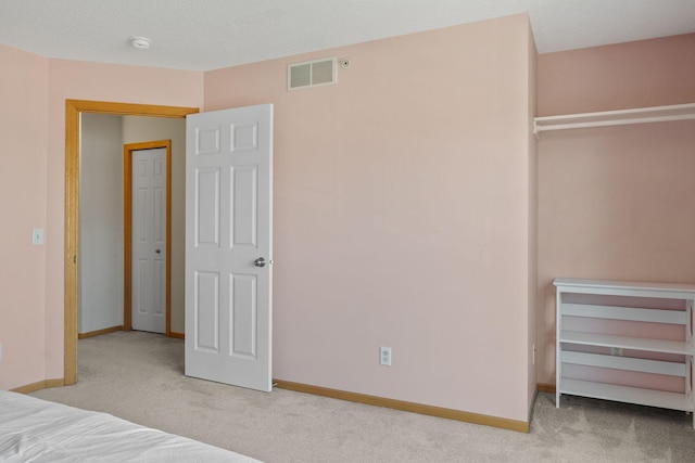 unfurnished bedroom with carpet floors, baseboards, and visible vents