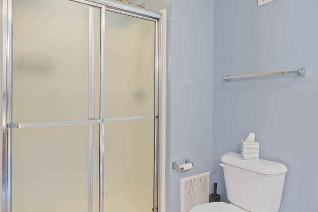 bathroom featuring toilet, visible vents, and a stall shower