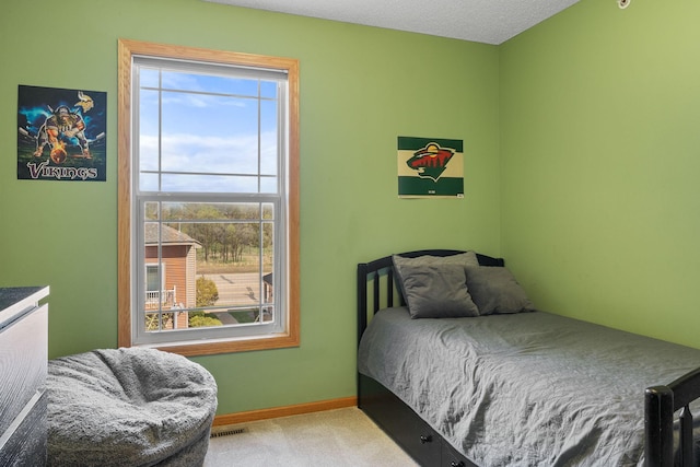carpeted bedroom featuring baseboards and visible vents