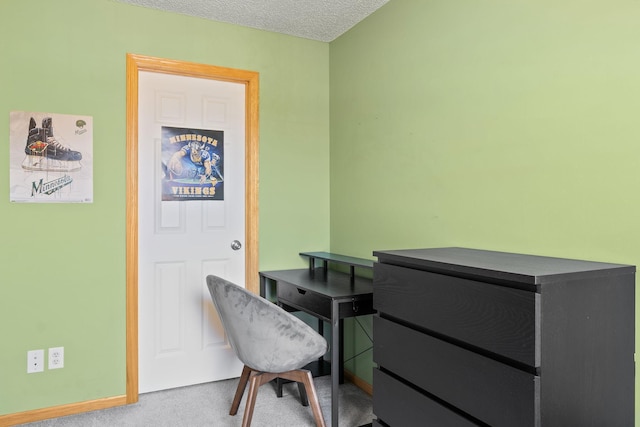 carpeted office space featuring a textured ceiling