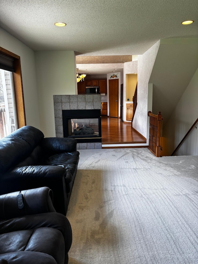 13852 Jasmine Way, Rogers, MN 55374 - living room featuring a textured ceiling, a fireplace, and dark carpet