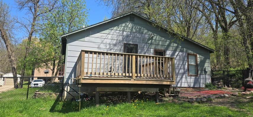 back of house with a lawn, fence, and a wooden deck