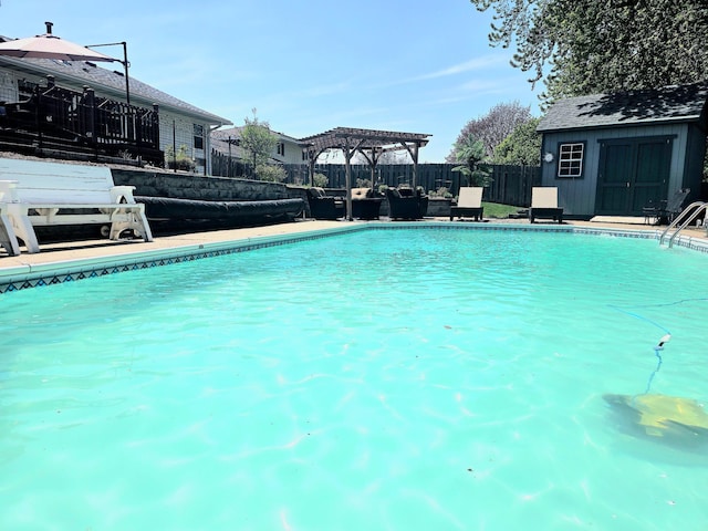 view of swimming pool with a pergola, a fenced backyard, and an outbuilding