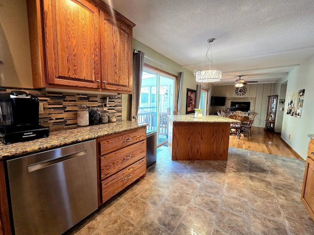 kitchen featuring dishwasher, decorative backsplash, brown cabinetry, light stone counters, and open floor plan