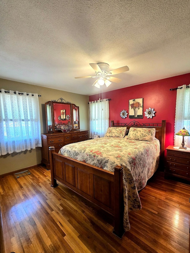 bedroom featuring wood finished floors, a textured ceiling, and ceiling fan