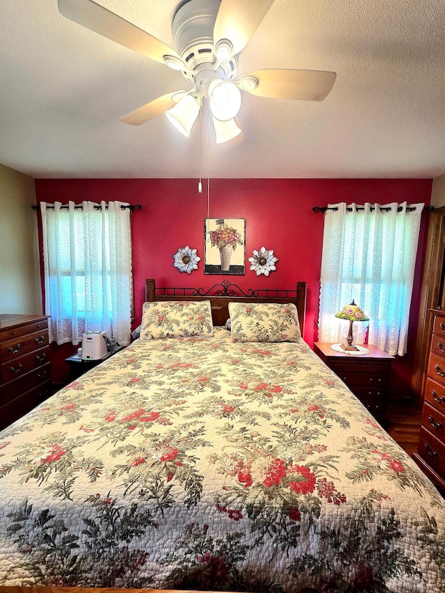 bedroom with a ceiling fan and a textured ceiling