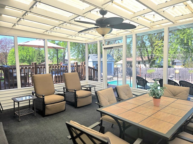 sunroom / solarium with a ceiling fan, outdoor dining space, and healthy amount of natural light